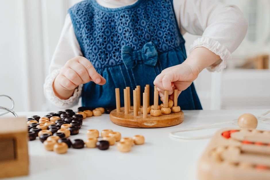 A child developing cognitive skills with a wooden sorting toy, an early cognitive development activity