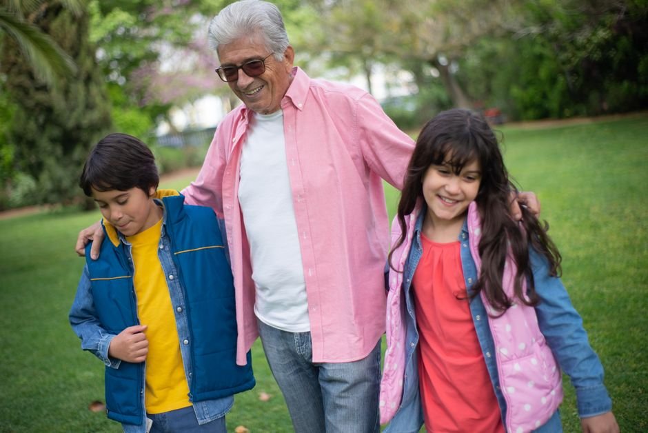 Grandfather and grandchildren enjoying grandkids activities and events together in a park