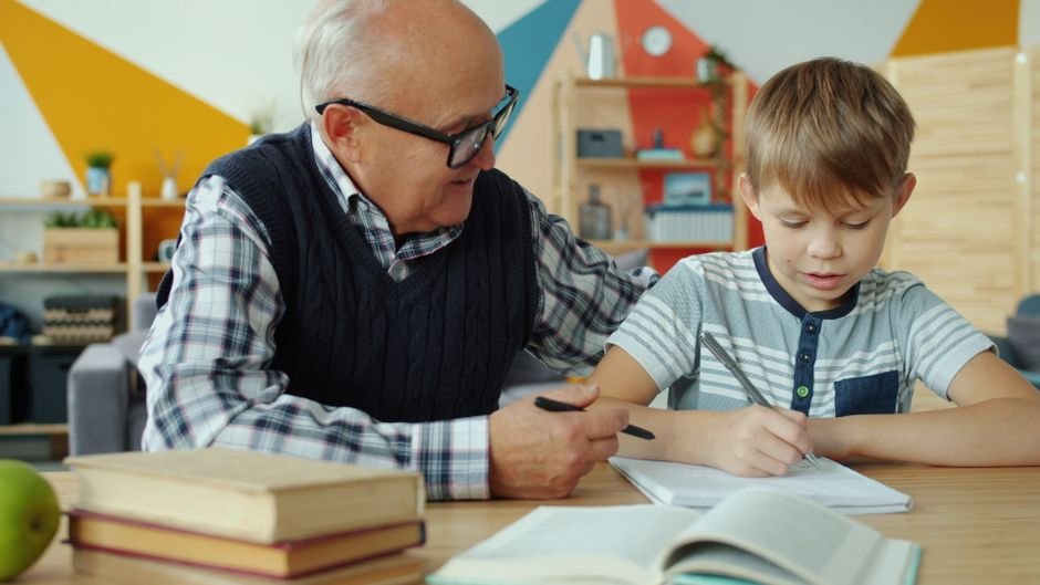 Grandfather helping grandson with one of these learning activities for grandkids indoors